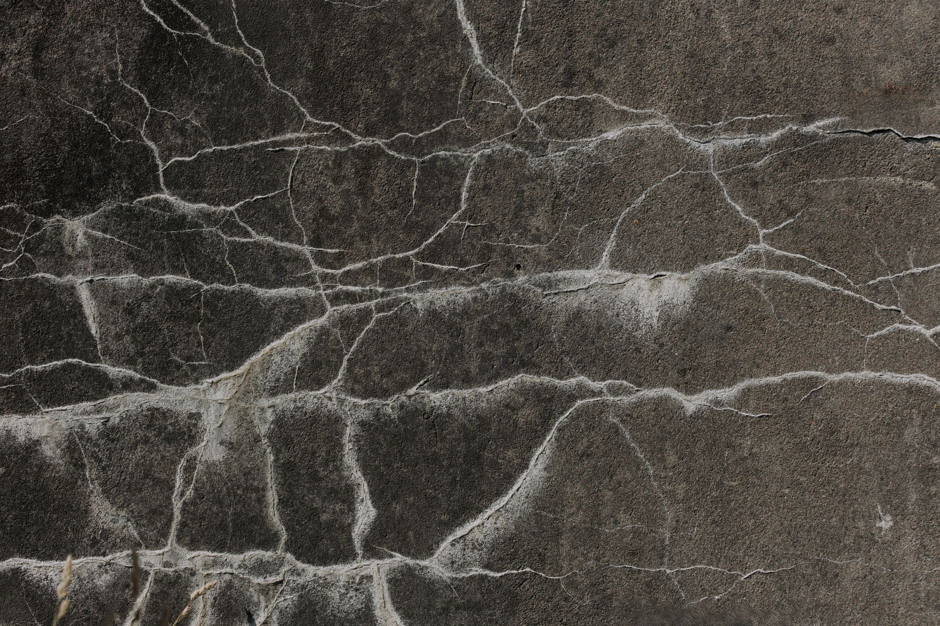 Close-up of cracking across a weathered concrete wall surface
