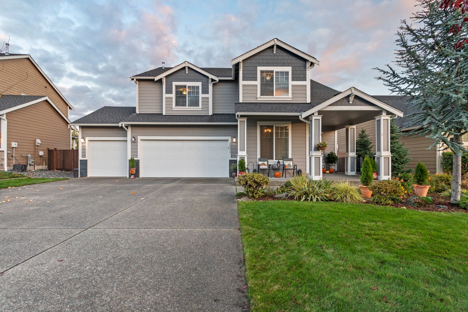 Two-story craftsman-style house with autumn plantings on the porch
