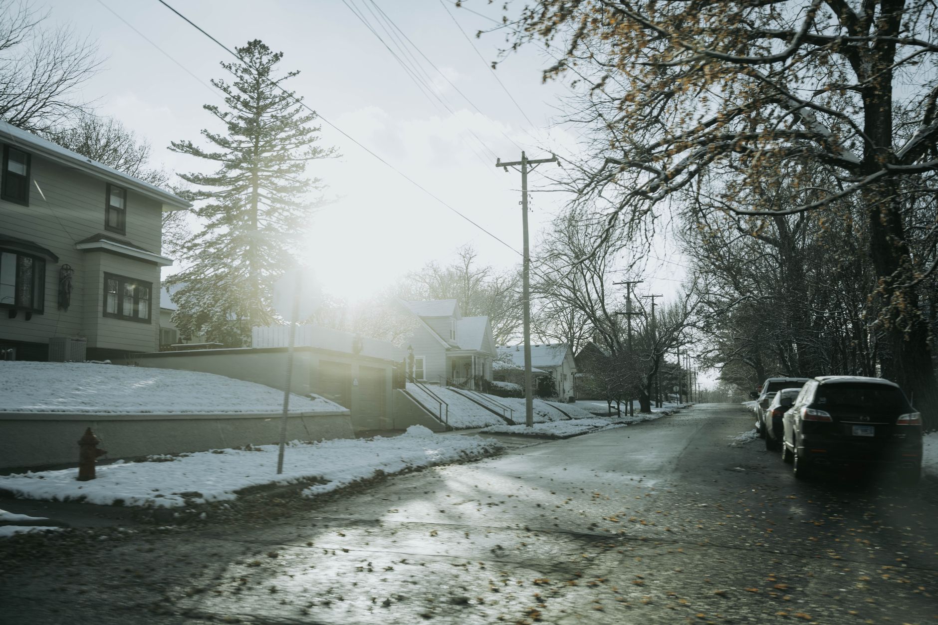 Snow-covered residential street lined with homes on a winter day