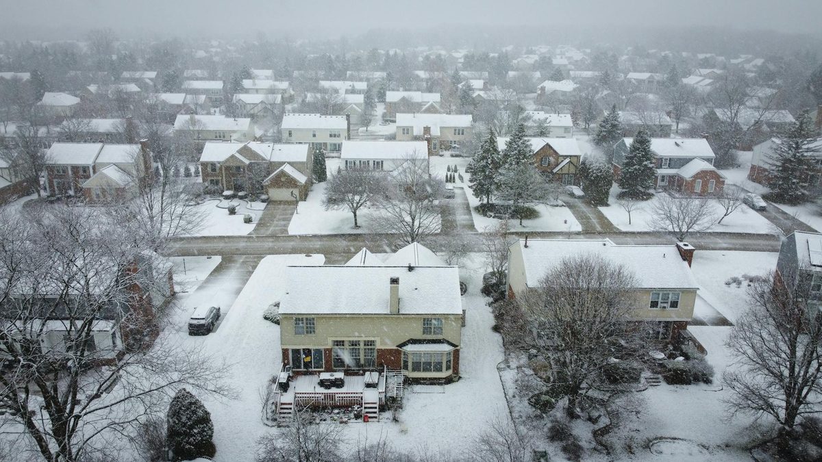 Aerial view of a snow-covered suburban neighborhood in winter